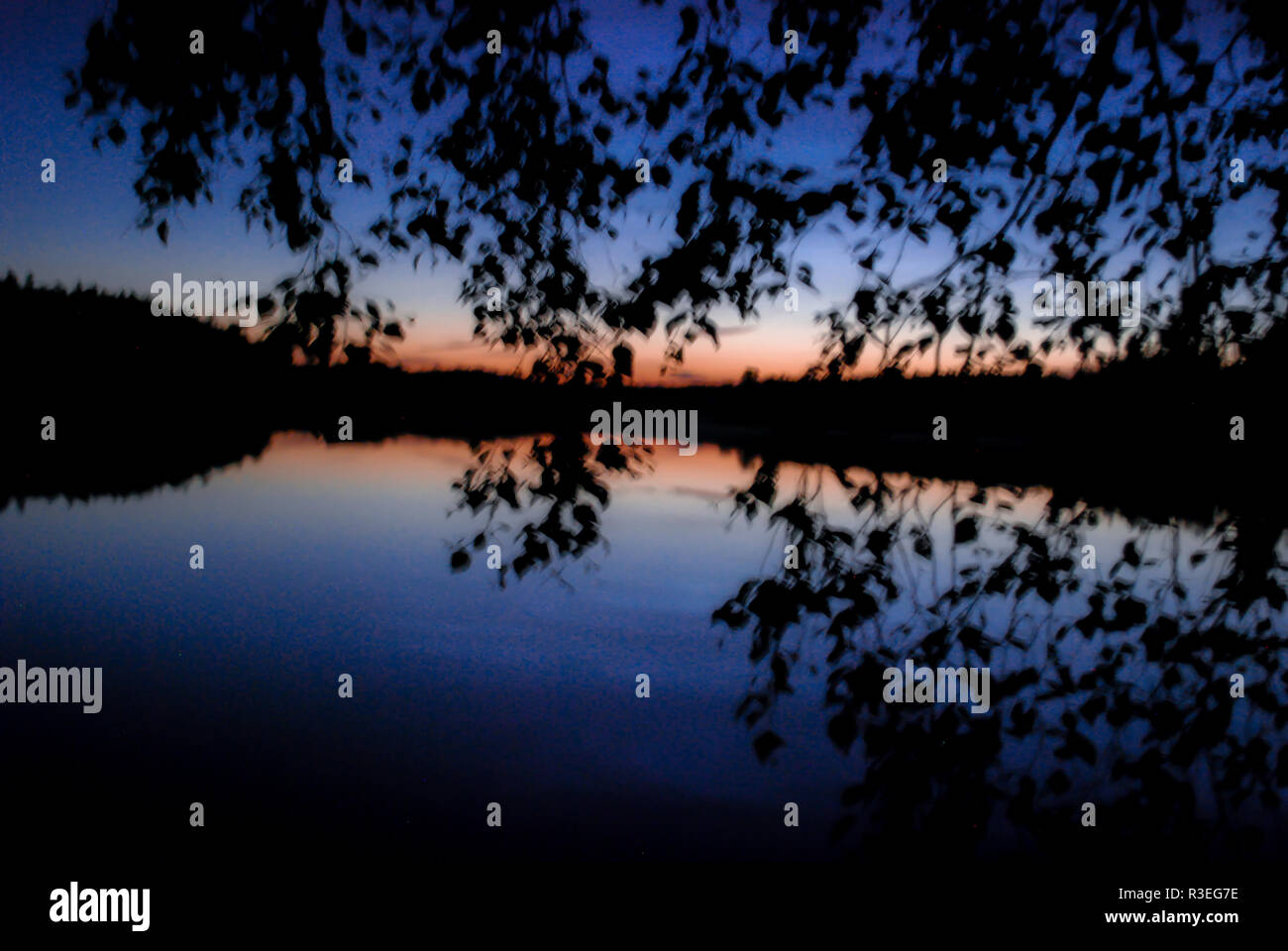 Blue hour over a lake with reflection in Skåne, southern Sweden Stock Photo