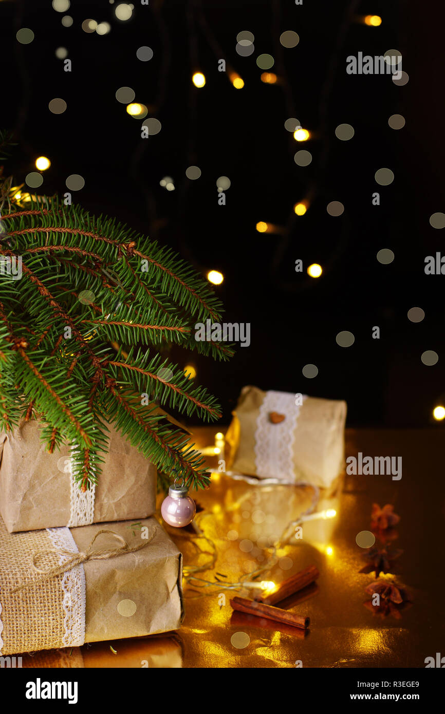 Christmas gifts are under the green tree with lights and glitter in a