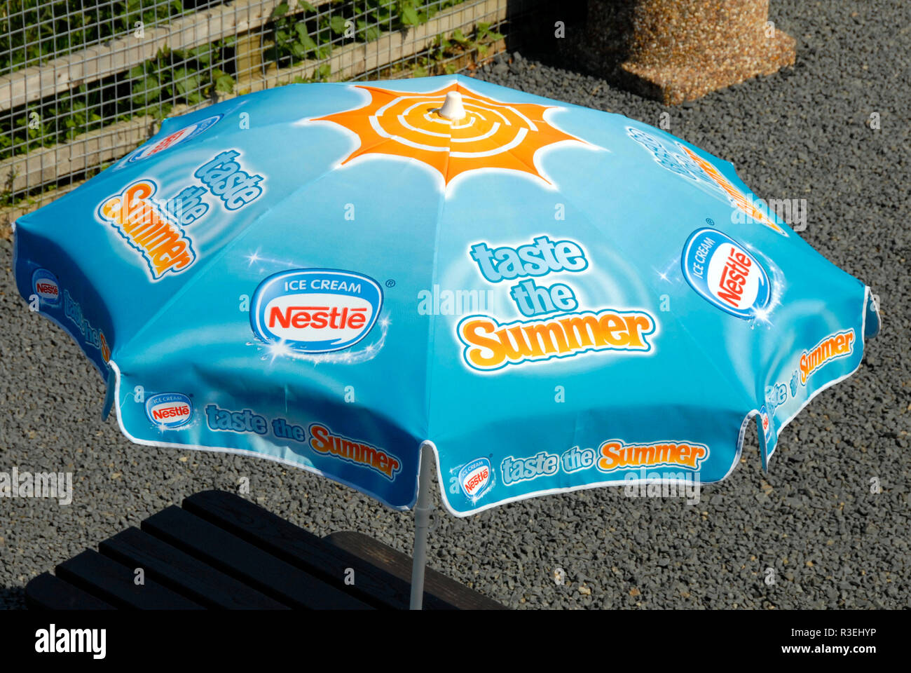 Parasol in restaurant garden with slogan 'Taste the Summer' and advertising for Nestle ice cream . Stock Photo