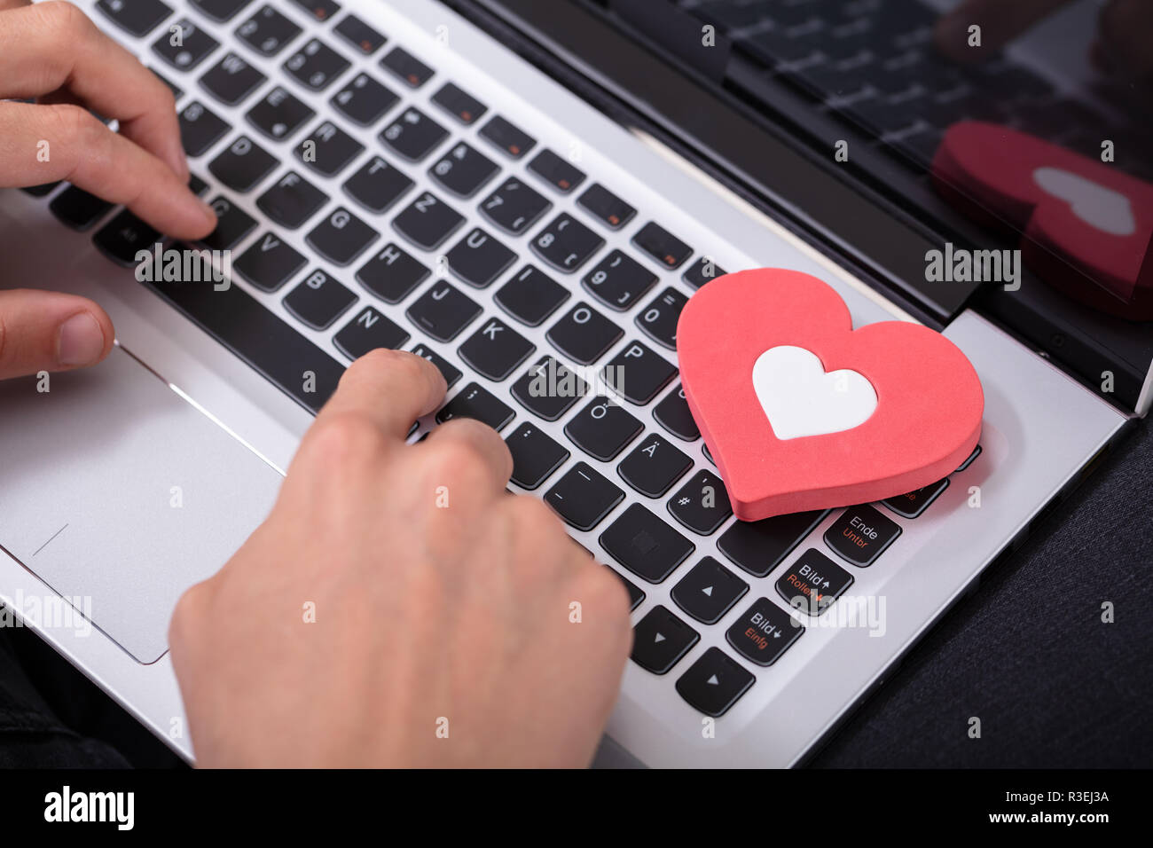 Person's Hand Typing On Laptop Keypad With Red Heart Stock Photo Alamy