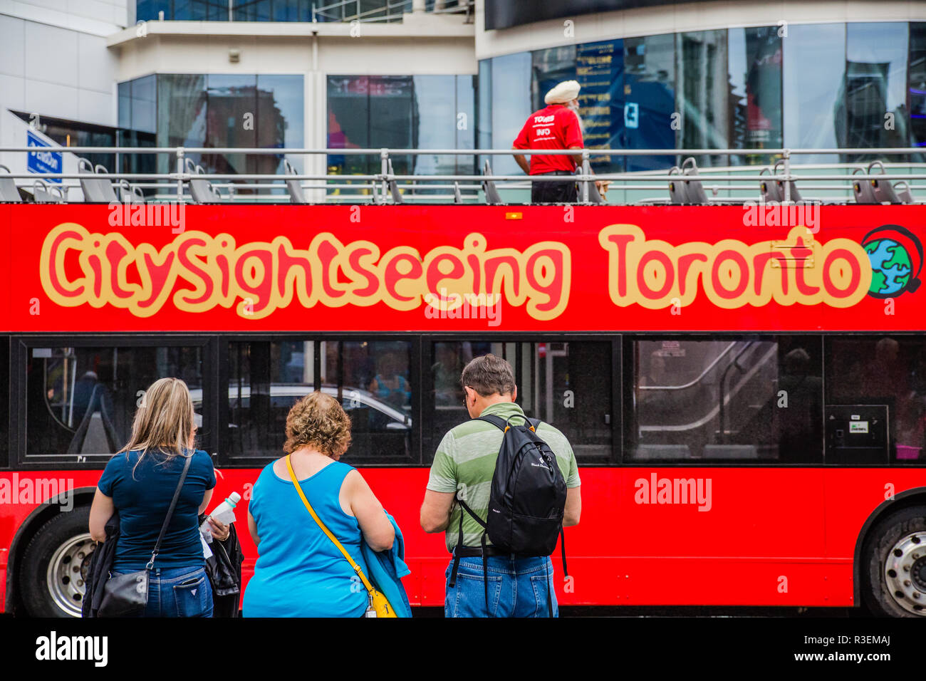 tourists lining up for toronto sightseeing bus red double decker tour bus Stock Photo