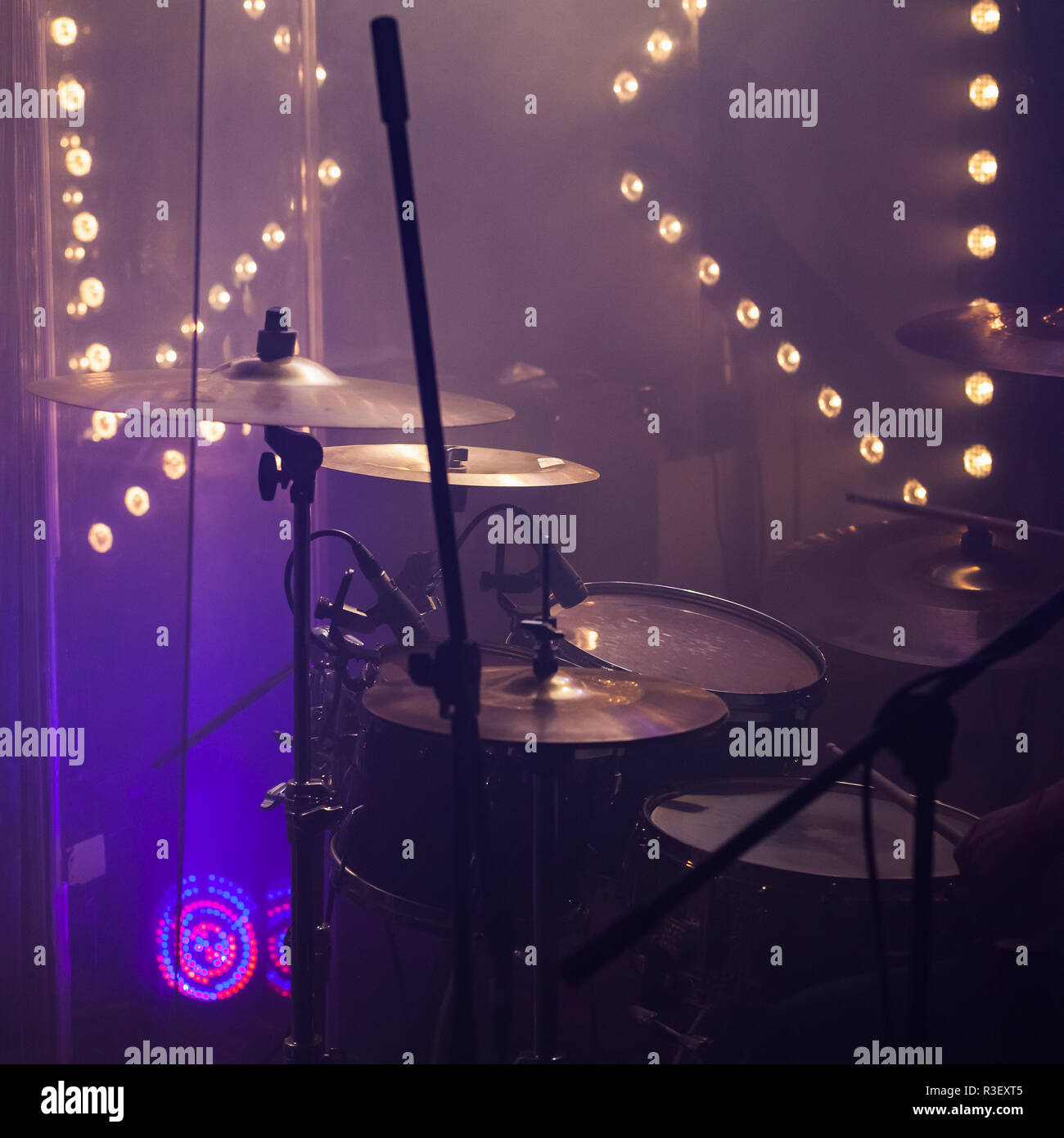 Live rock music photo background, rock drum set  with cymbals in stage lights. Close-up square photo, soft selective focus Stock Photo