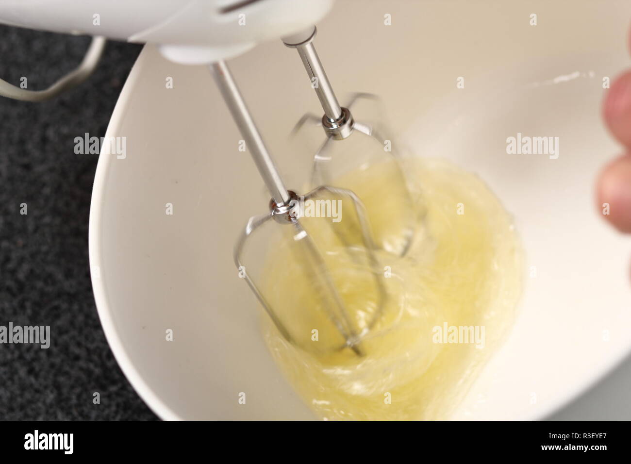 Beat up egg whites using handheld mixer Stock Photo Alamy