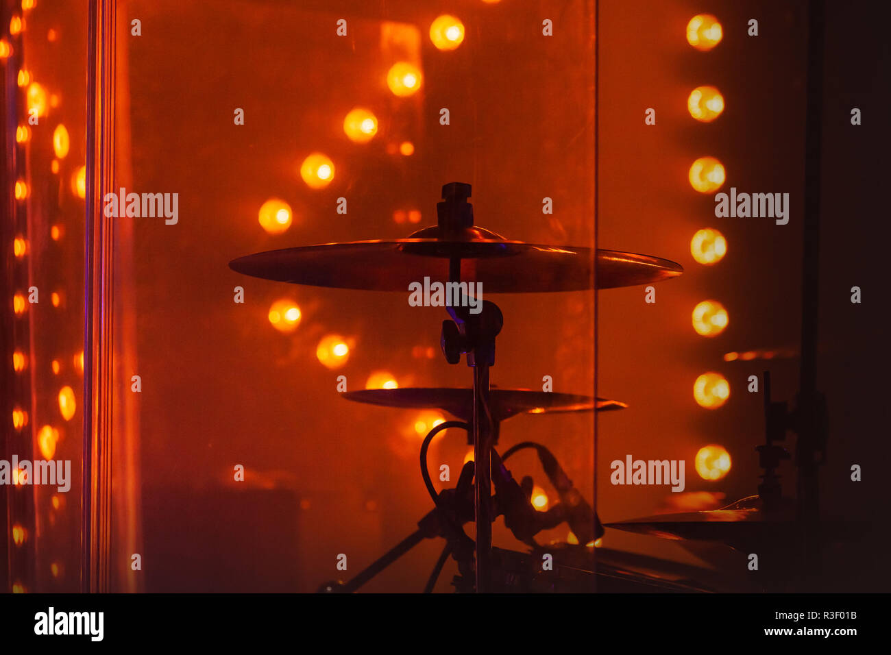 Live rock music photo background, rock drum set  with cymbals in red stage lights. Close-up photo, soft selective focus Stock Photo