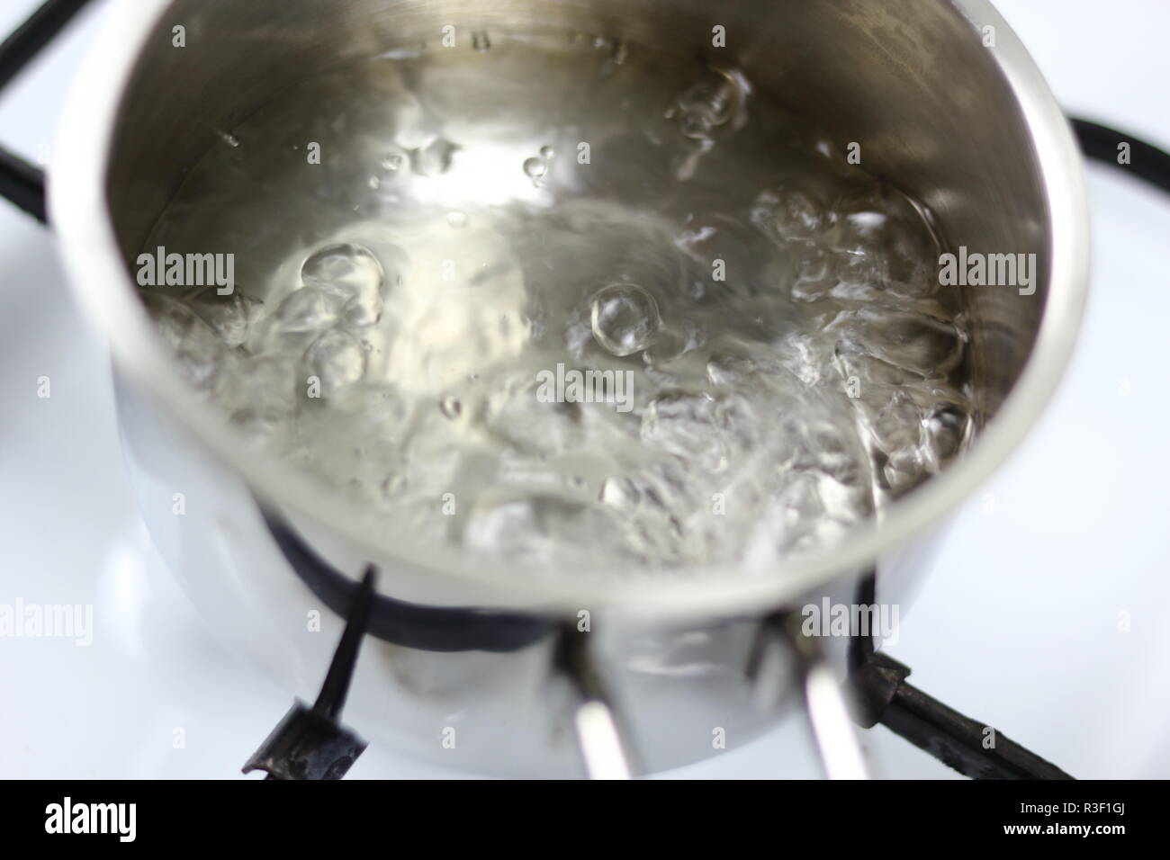 Boiling water in milk pan on gas stove Stock Photo - Alamy