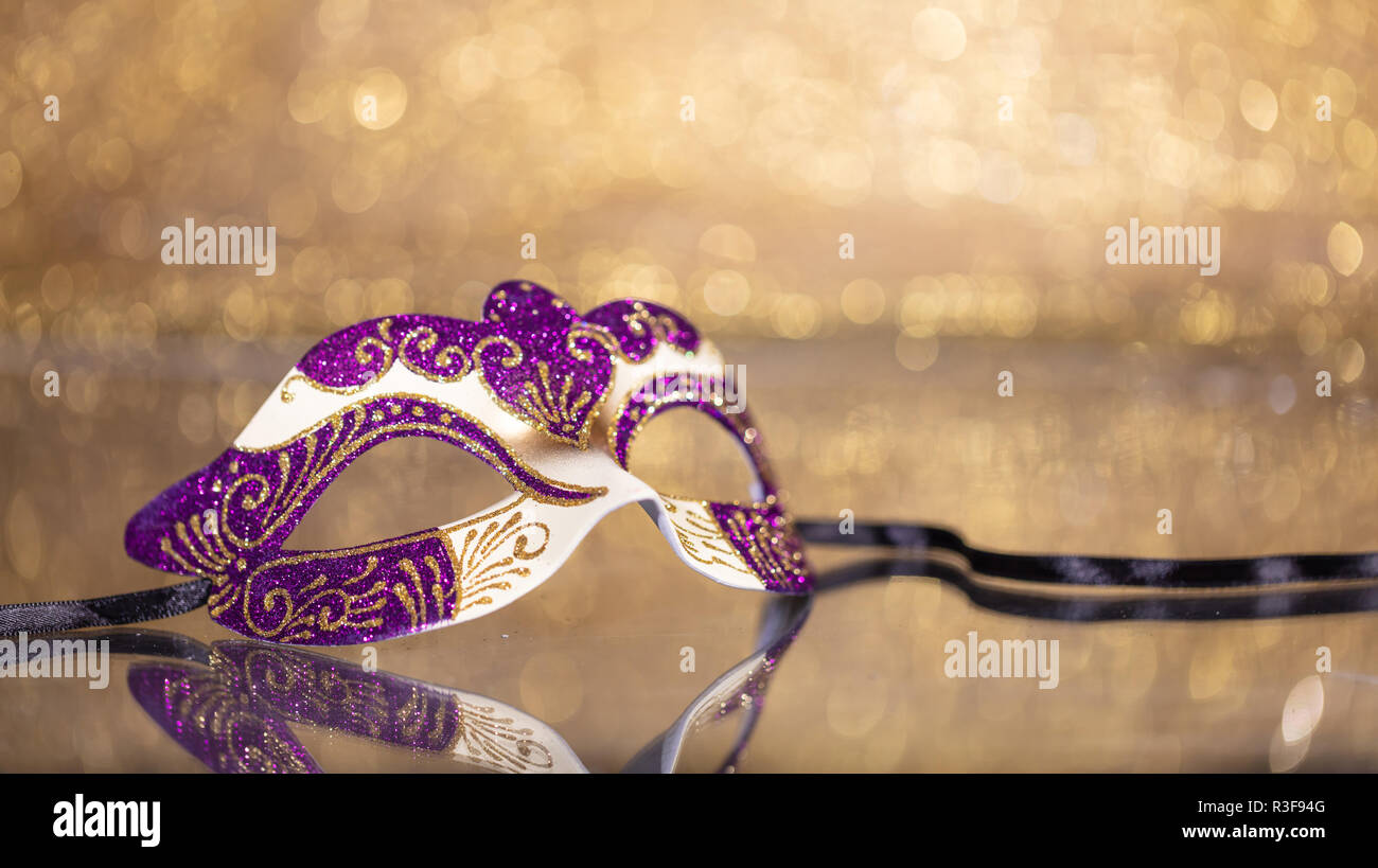 Carnival time. Venetian mask on golden bokeh background, reflections, copy space Stock Photo