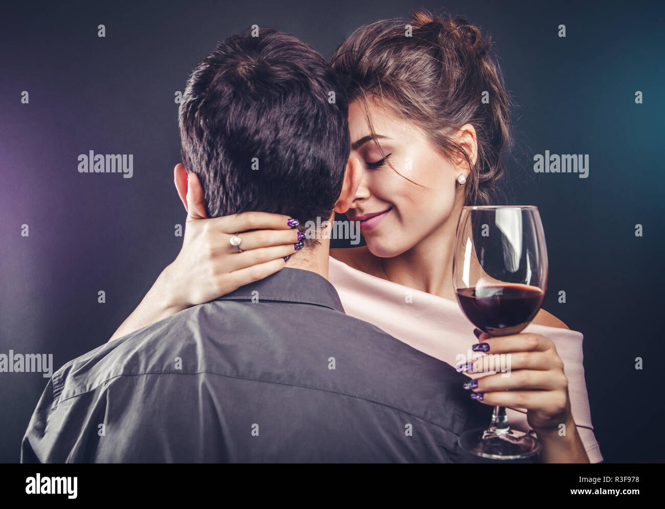 Couple celebrating Valentines day drinking red wine on black background ...