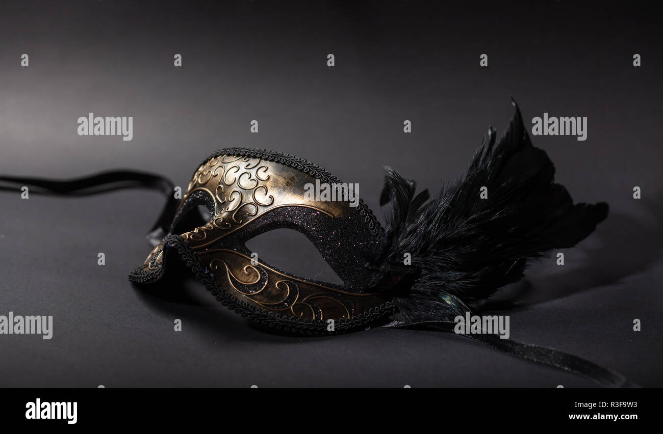 Carnival time. Venetian mask with feathers on black background, copy space Stock Photo