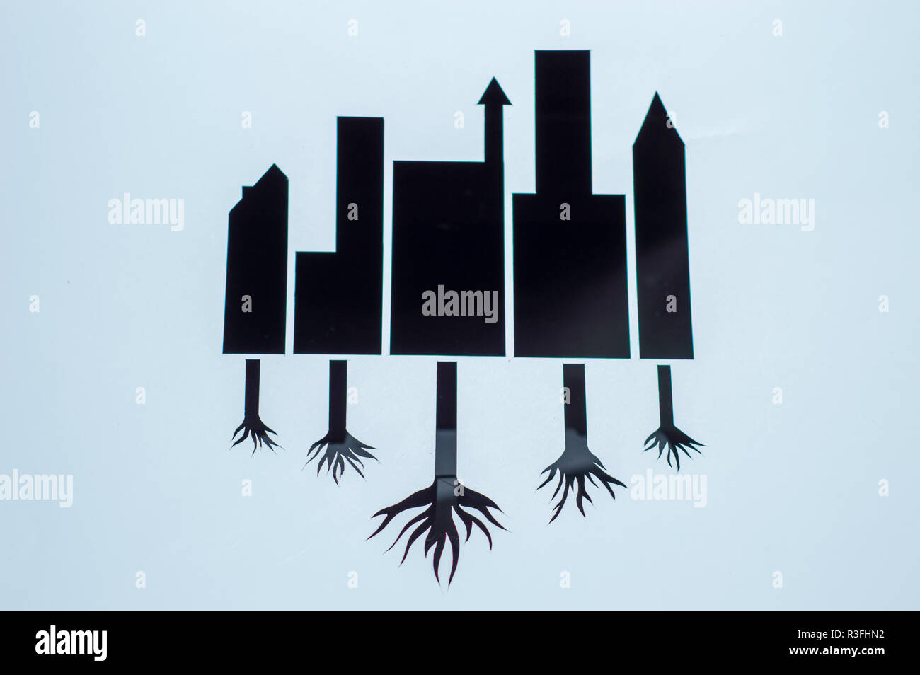 cutting paper illustration save earth. black building with root of trees Stock Photo