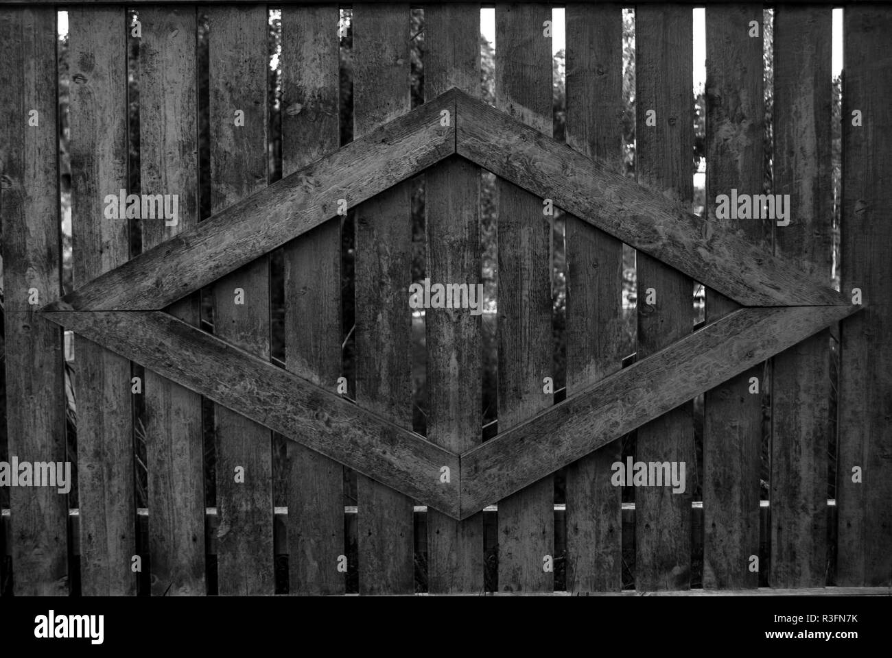 A wooden fence with a dimond shape attatched to the fence black and white, Glava, Sweden Stock Photo