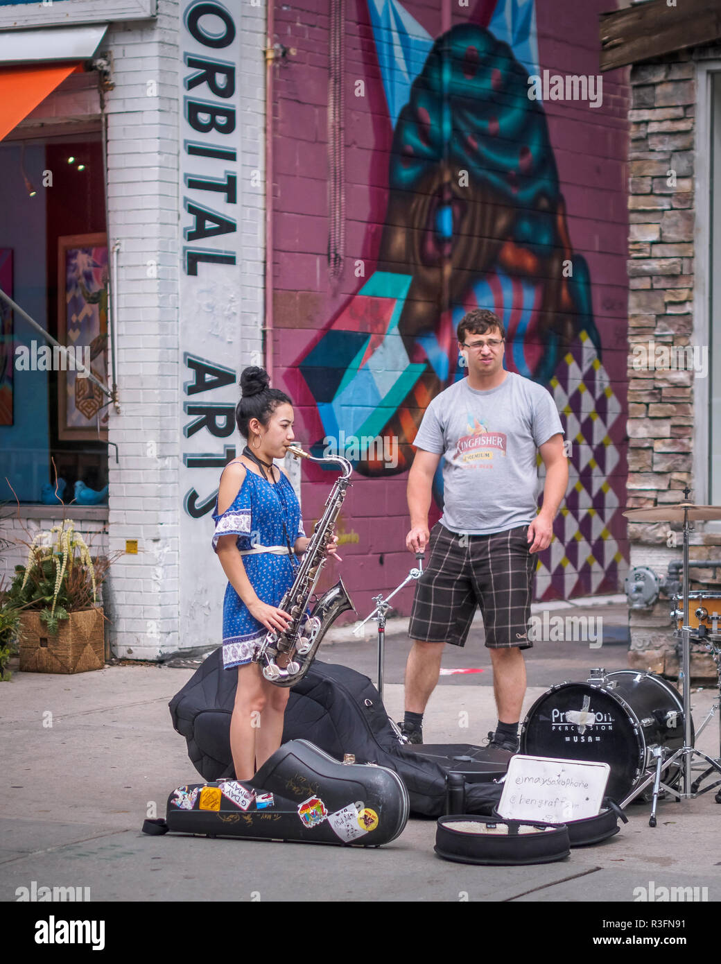 A girl playing saxophone, street performance, during summers in Kensington Market, Toronto, Ontario, Canada Stock Photo