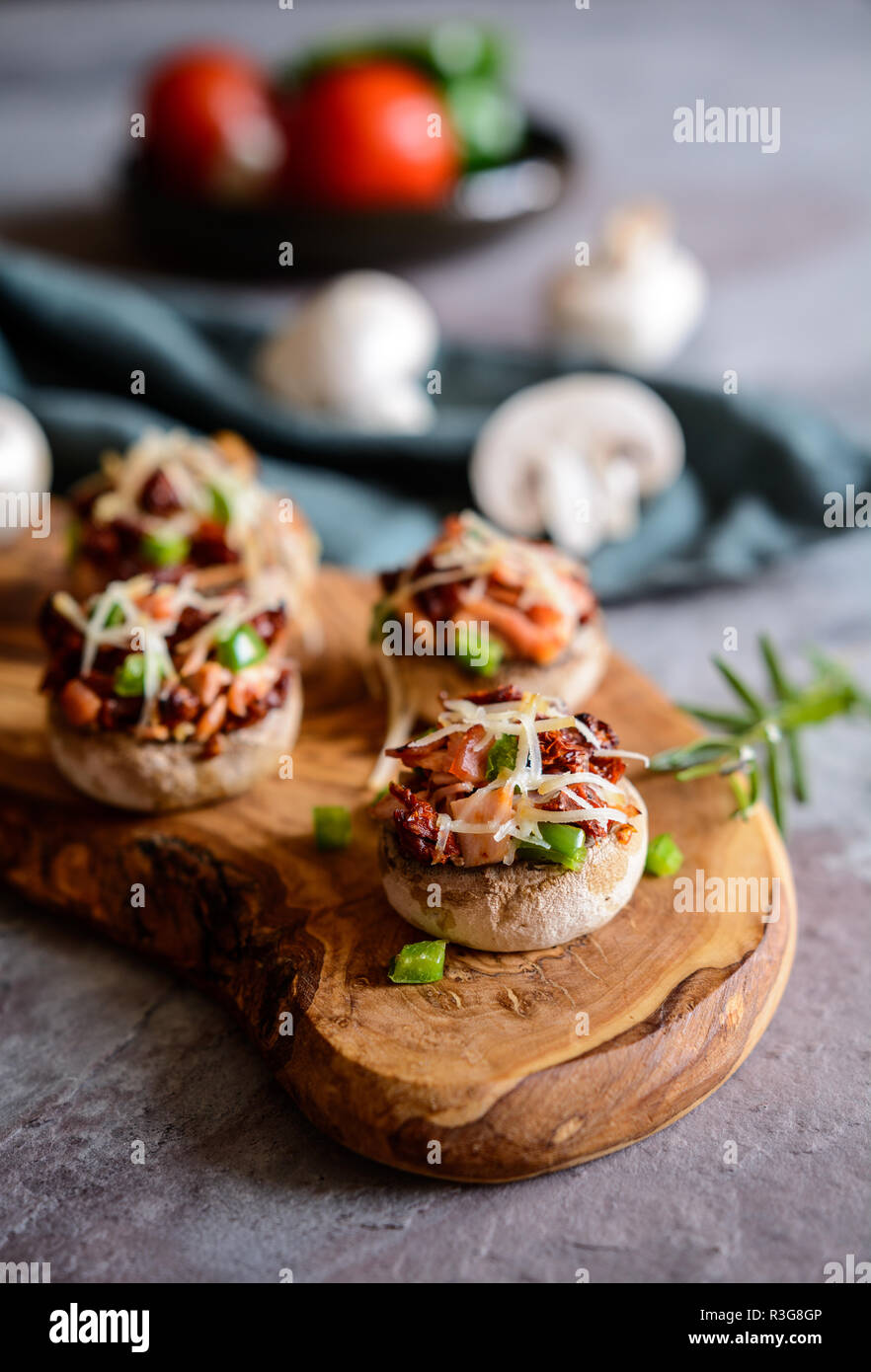 Roasted mushrooms stuffed with sliced ham, sun dried tomato and green bell pepper Stock Photo
