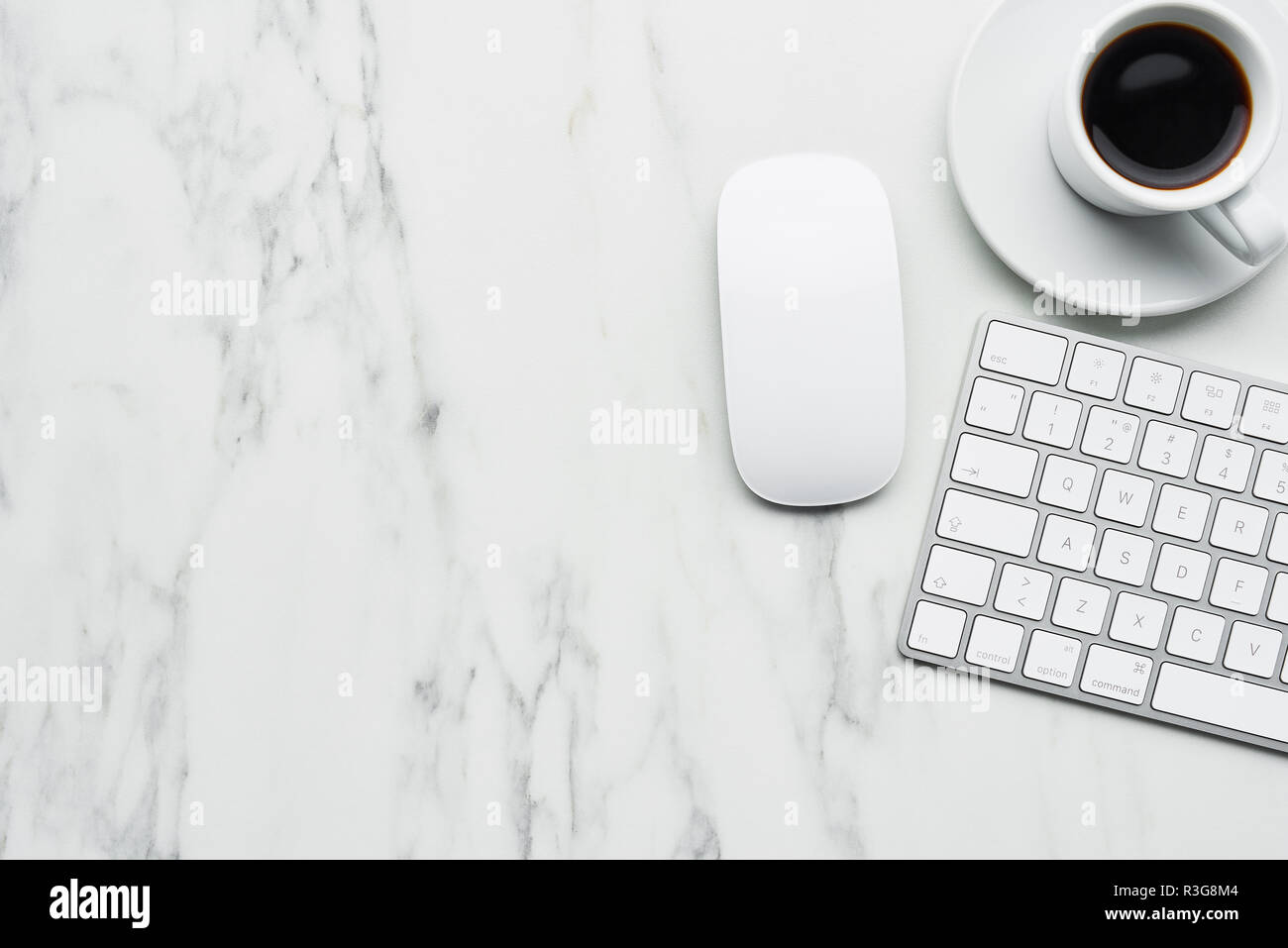 Business composition with white computer keyboard, mouse and coffee cup on white marble background. Coffee break concept. Top view with copy space for Stock Photo