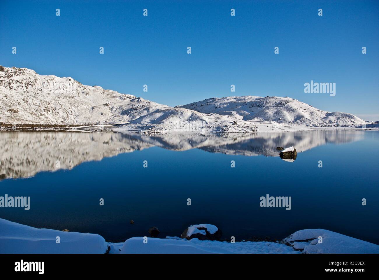 Snow covered hills reflected in a mountain lake, Mount Snowdon, Snowdonia National Park, Gwynedd, North Wales, UK Stock Photo