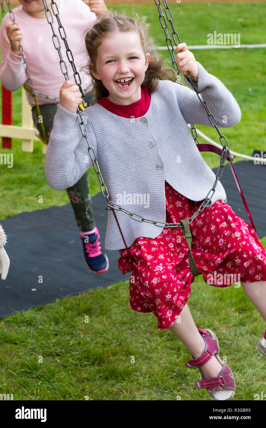 Six year old girl rides a traditional vintage old classic roundabout ...