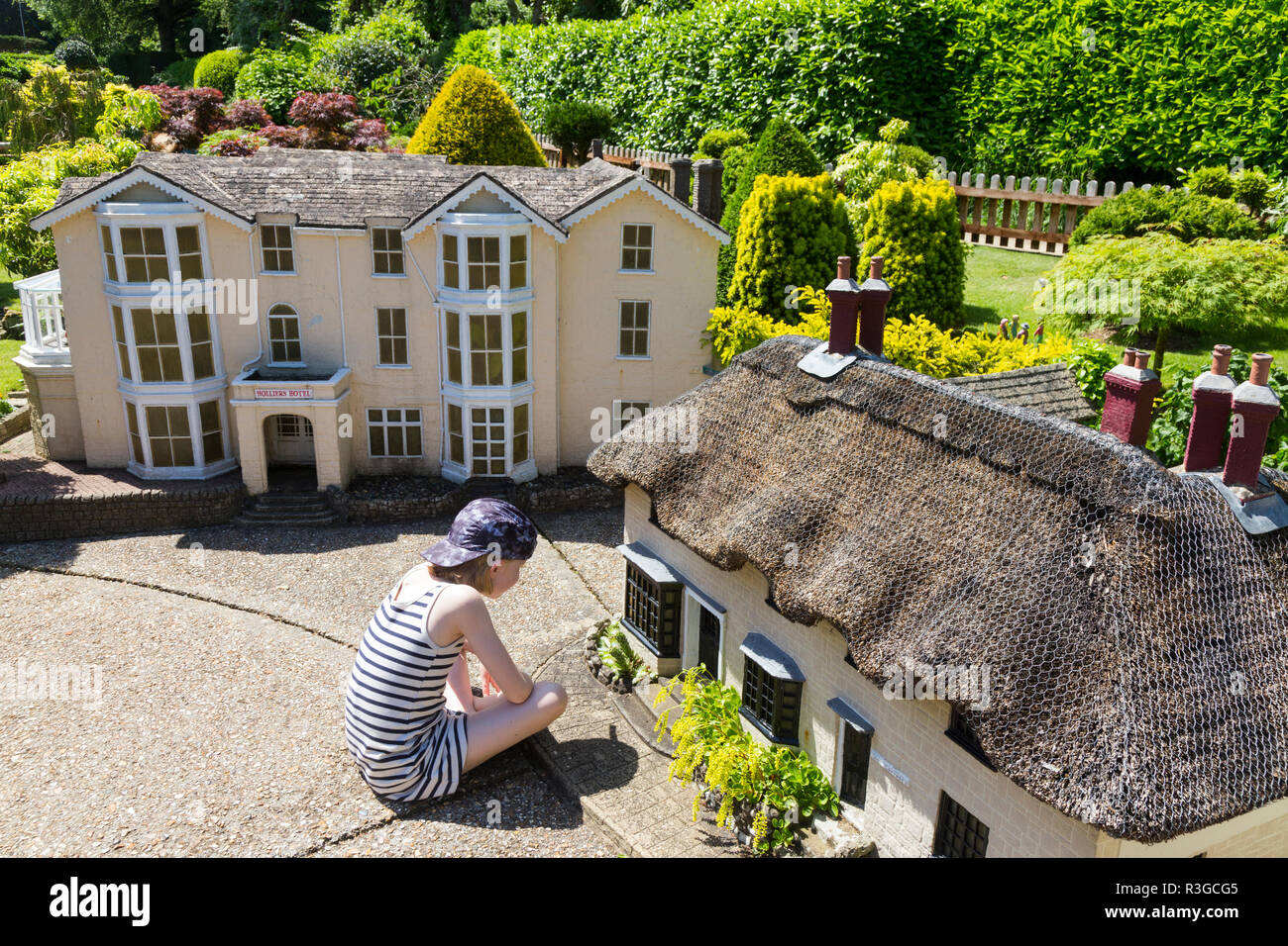 Girl / girls / child / children / kid / kids explore the Model Village at Godshill on the Isle of Wight, on a sunny day with blue sky / skies. (98) Stock Photo