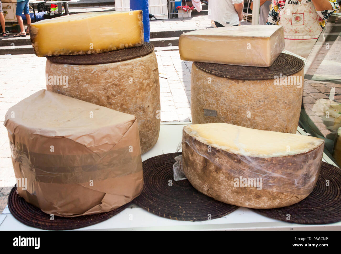 selection of half wheel French hard cheeses in an outdoor french street market in Sarlat Stock Photo