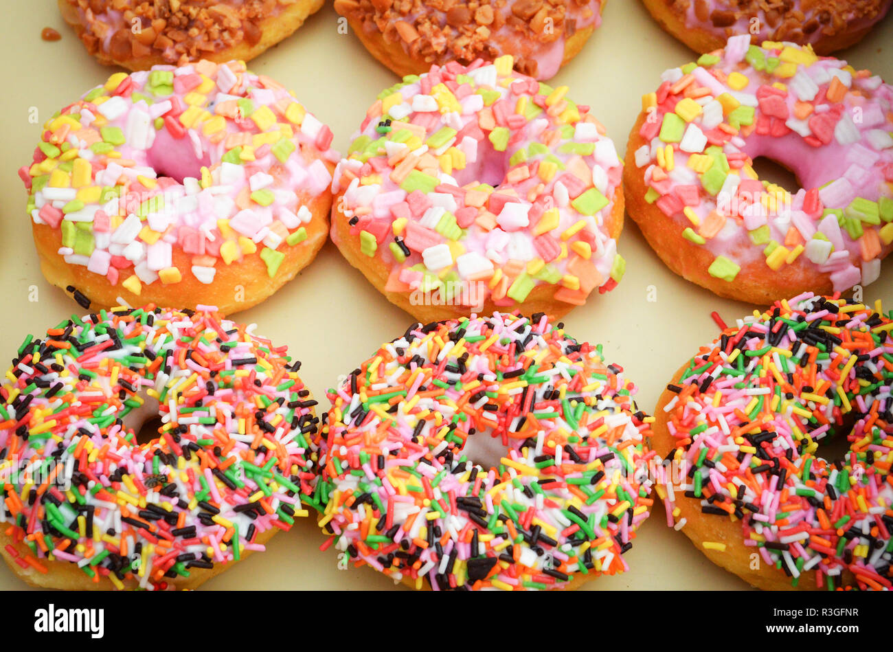donuts background / set of various colorful donuts top view on tray ...