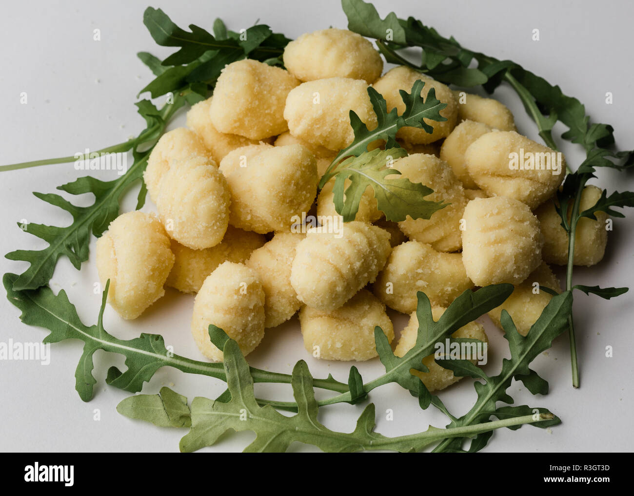Raw uncooked Gnocchi with arugula salat Stock Photo