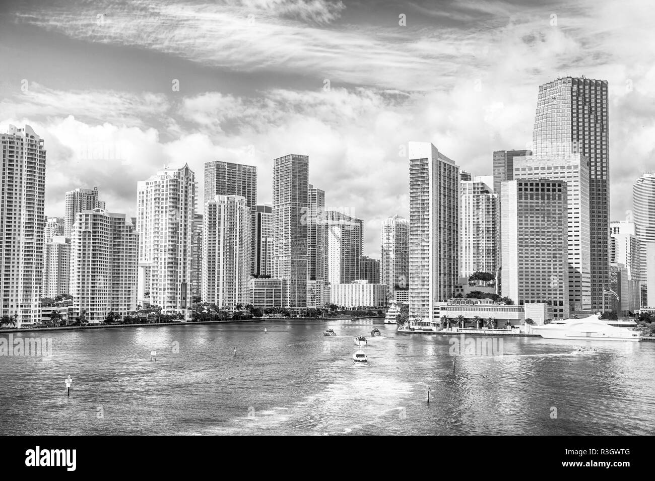 miami life. Aerial view of Miami skyscrapers with blue cloudy sky, white boat sailing next to