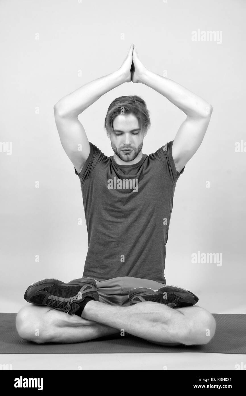 Sportsman relax in lotus pose. Man meditate on yoga mat. Fashion athlete practice yoga in gym. Meditation for body and mind health. Meditation or zen  Stock Photo