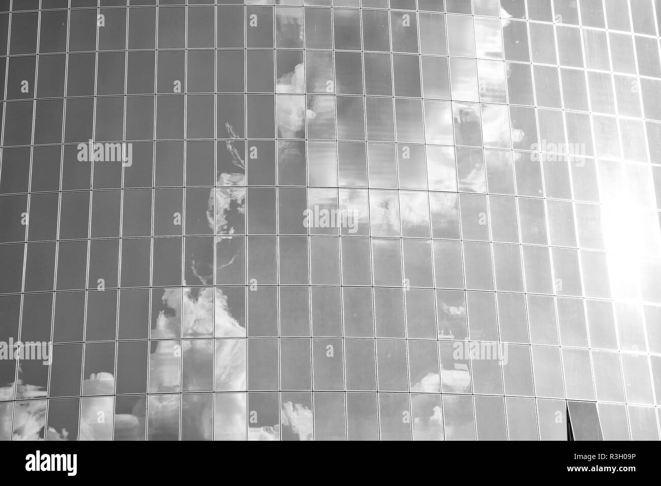Clouds reflected on glass facade wall of building. Cloudy blue sky ...