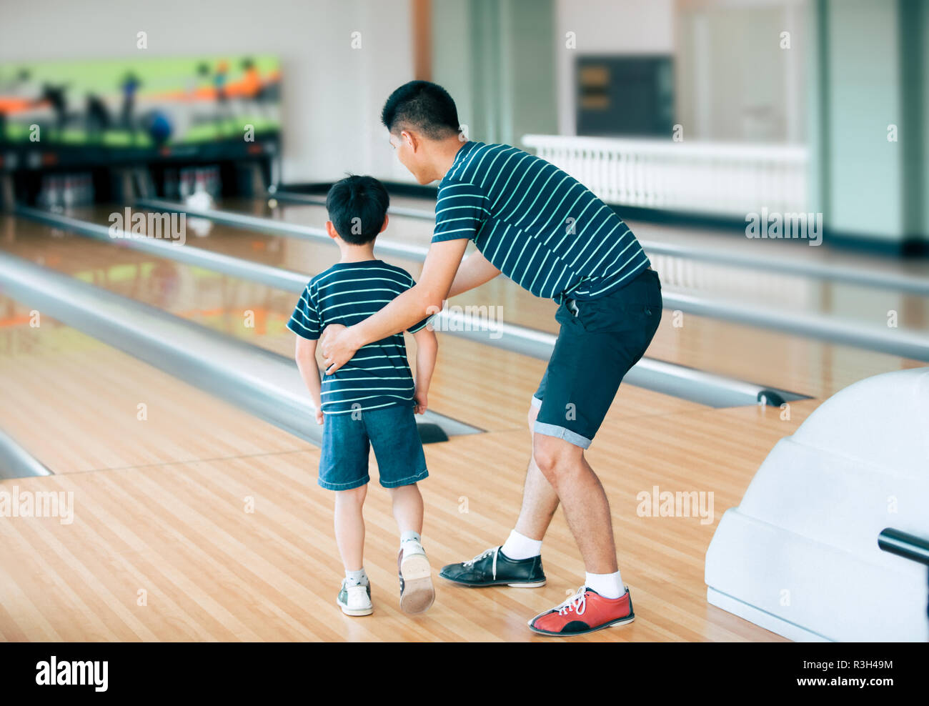 Father teaching son for play bowling at bowling club Stock Photo