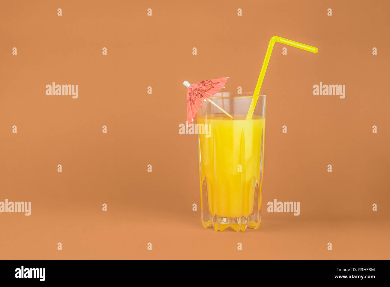 Orange cocktail drink on red background.  Image of citrus juice glass at bright minimalistic environment. Stock Photo
