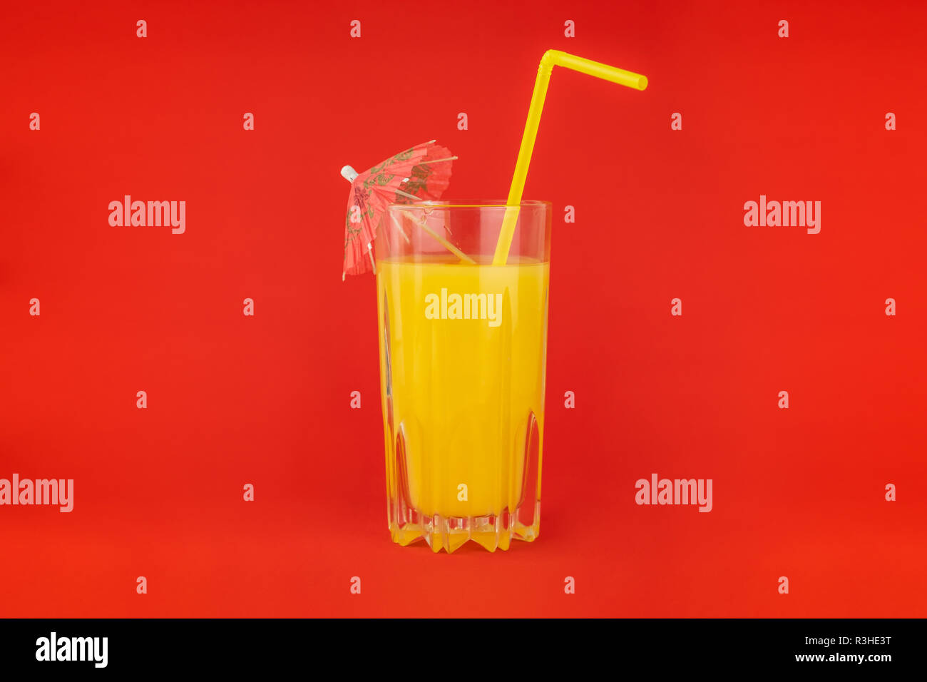 Orange cocktail drink on red background.  Image of citrus juice glass at bright minimalistic environment. Stock Photo