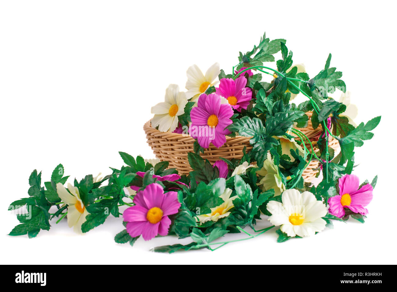 Colorful fabric flowers in wicker basket isolated on white background. Stock Photo
