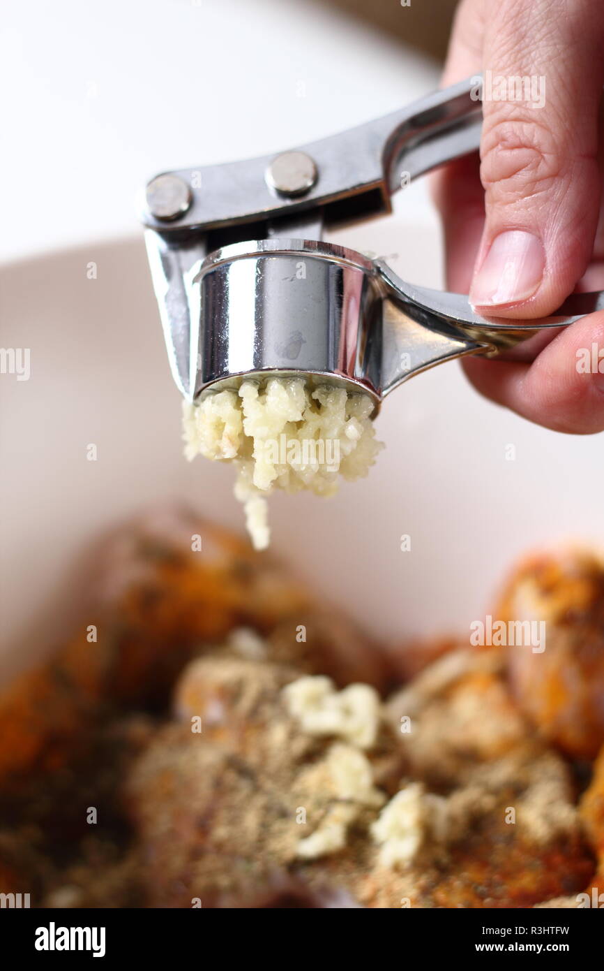 Garlic crushed using a garlic press Stock Photo Alamy