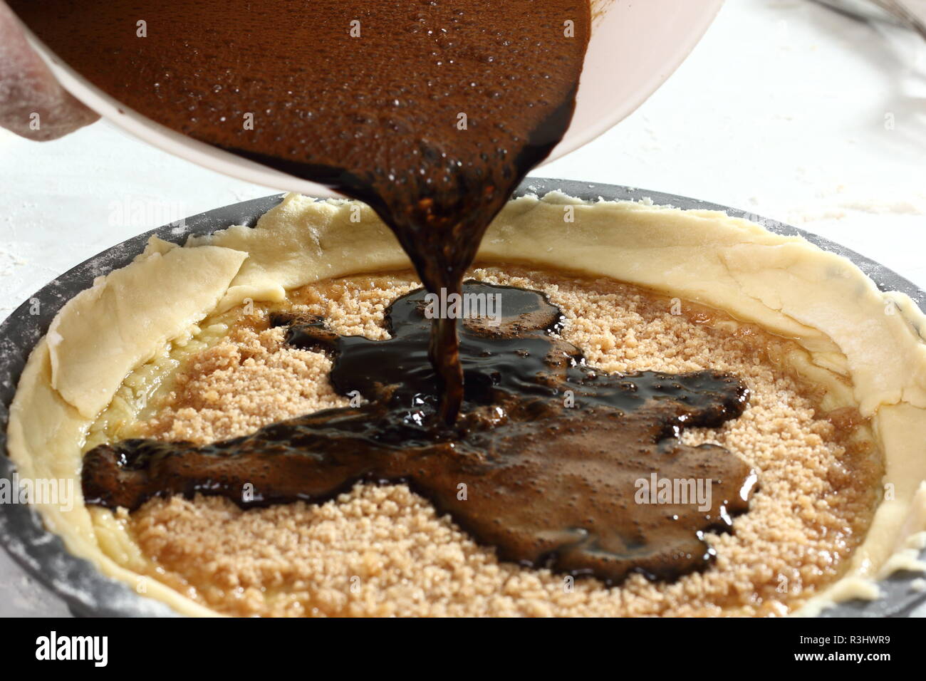 Pouring molasses and eggs mixture into pastry case. Making Treacle Pie
