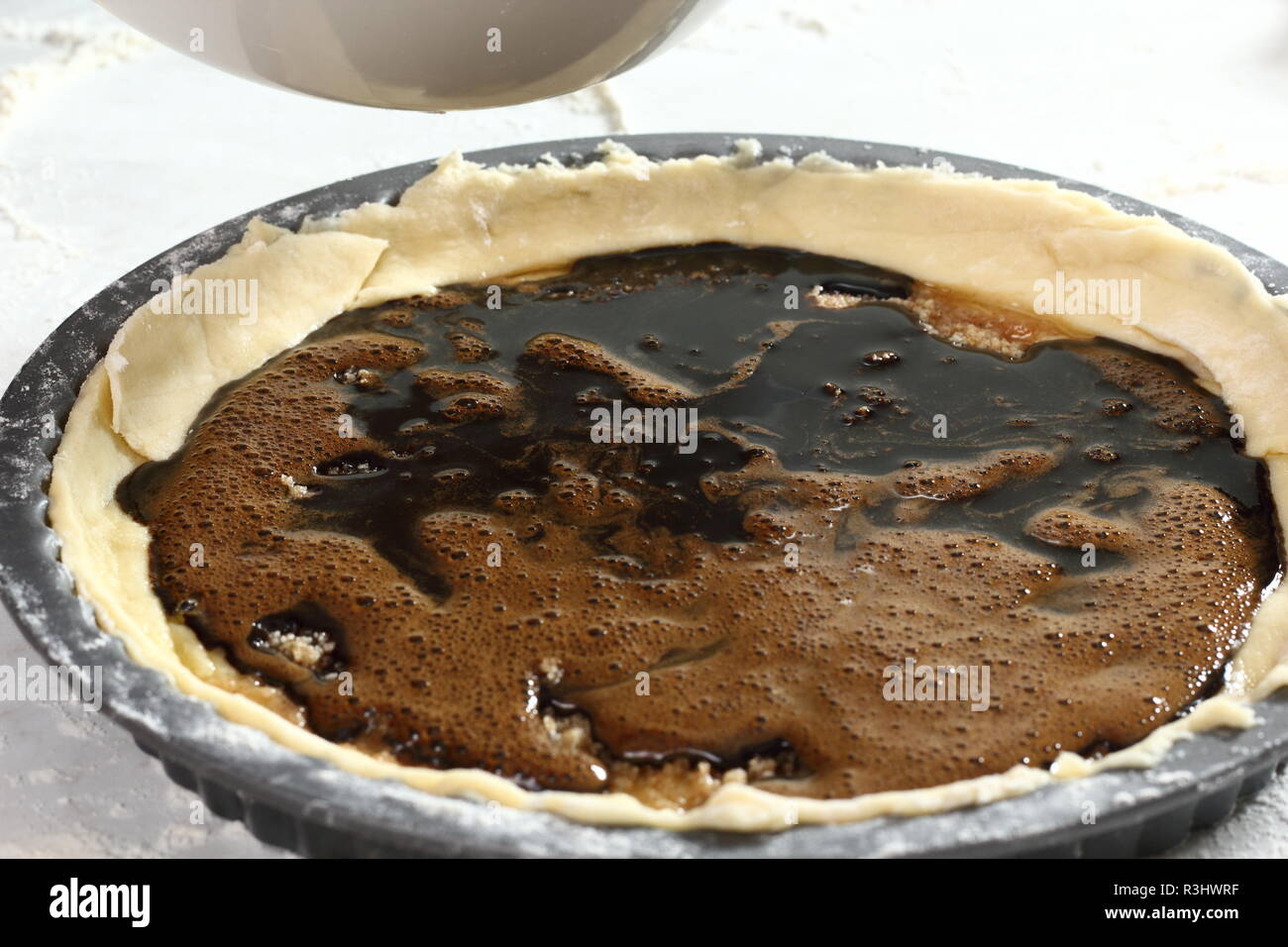 Pouring molasses and eggs mixture into pastry case. Making Treacle Pie