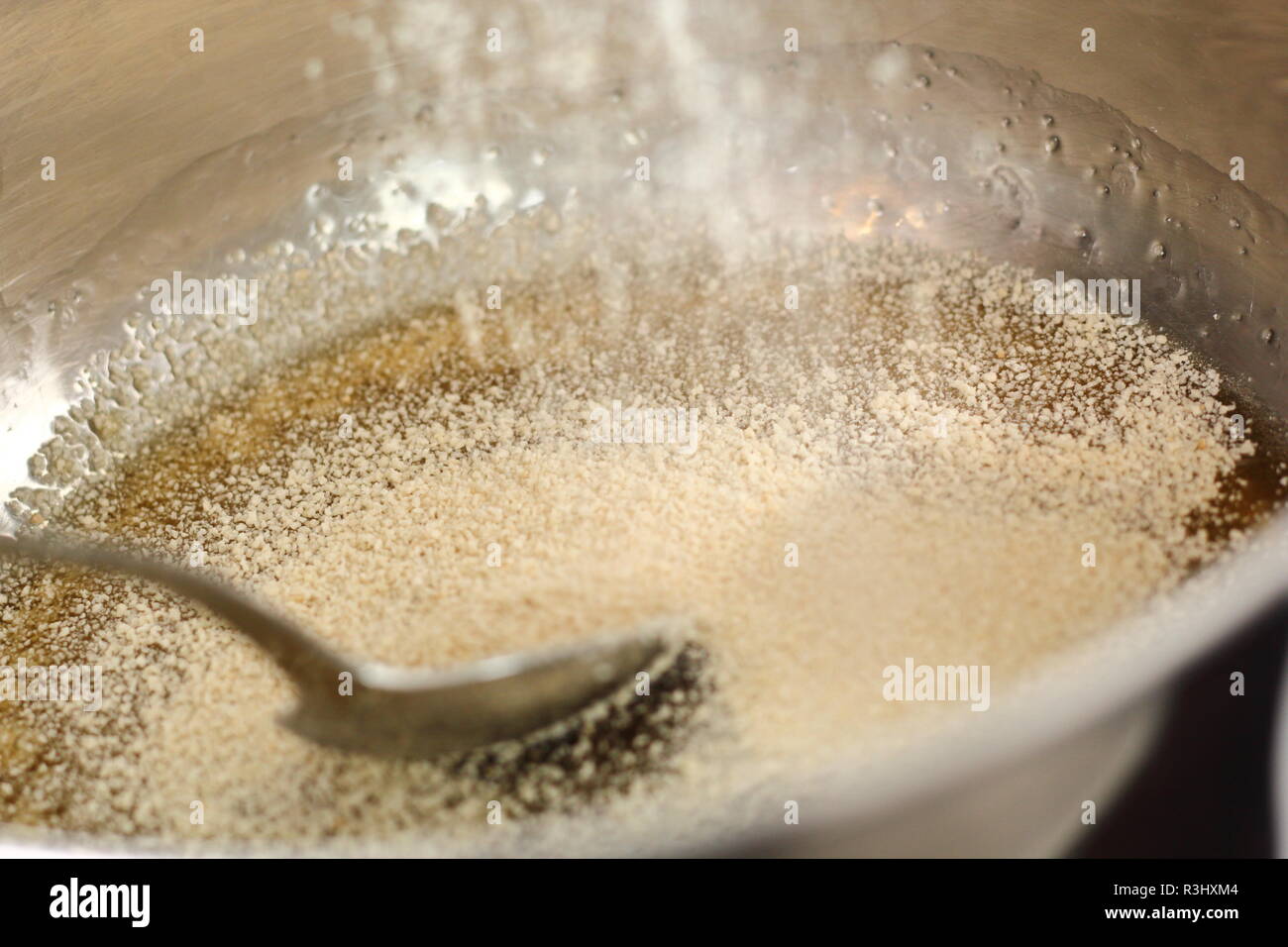 Pouring white breadcrumbs into saucepan with golden syrup. Making