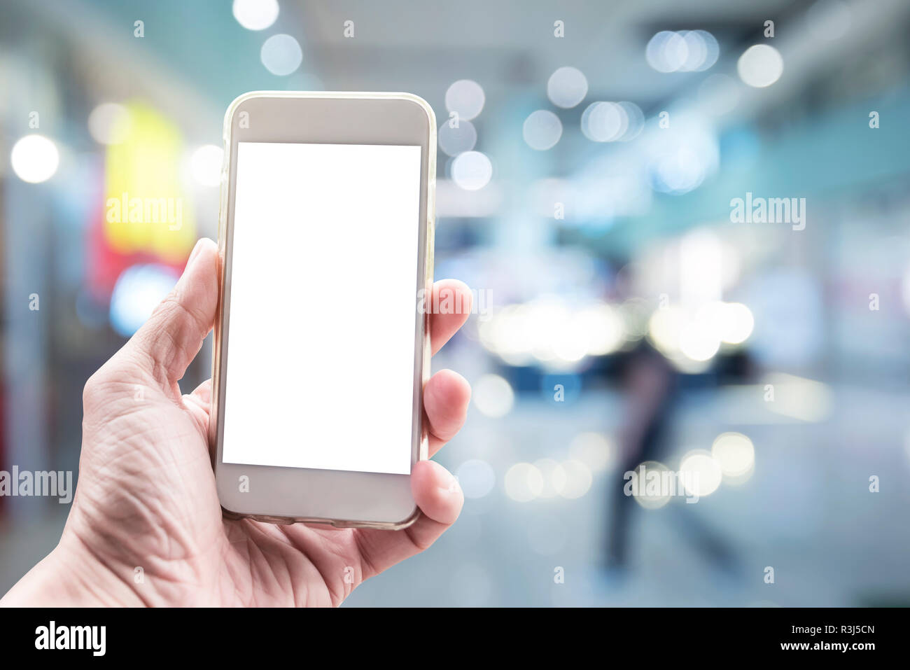 Blank white screen mobile on hand with blurred city light background. Business and technology