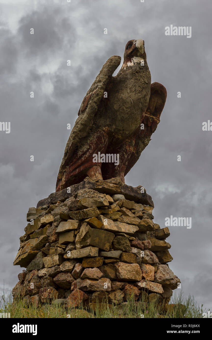 Golden eagle made of stone along the road, Issyk Kul region, Kyrgyzstan Stock Photo