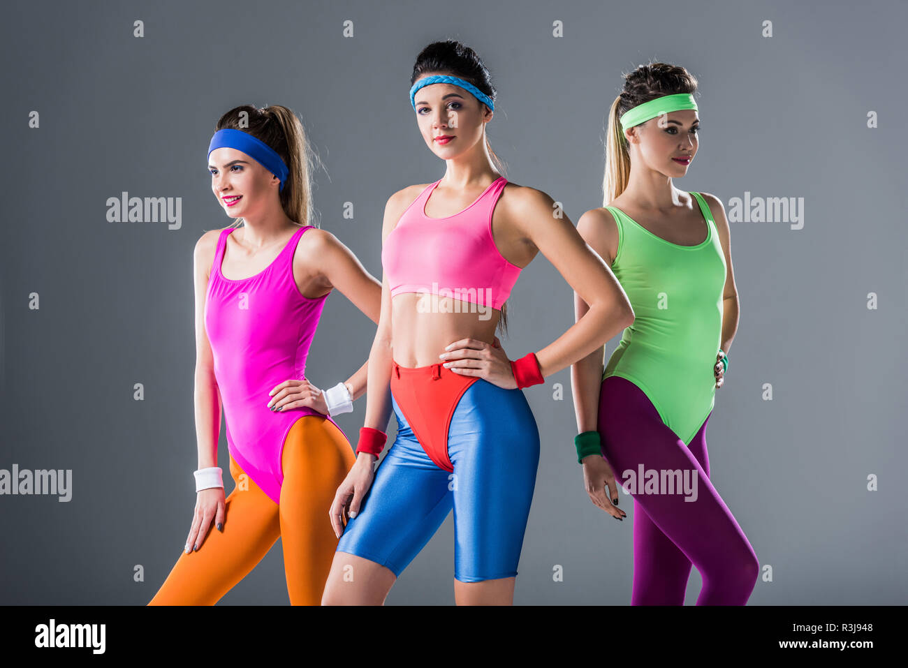 beautiful sporty girls in 80s style sportswear posing together isolated on  grey Stock Photo - Alamy