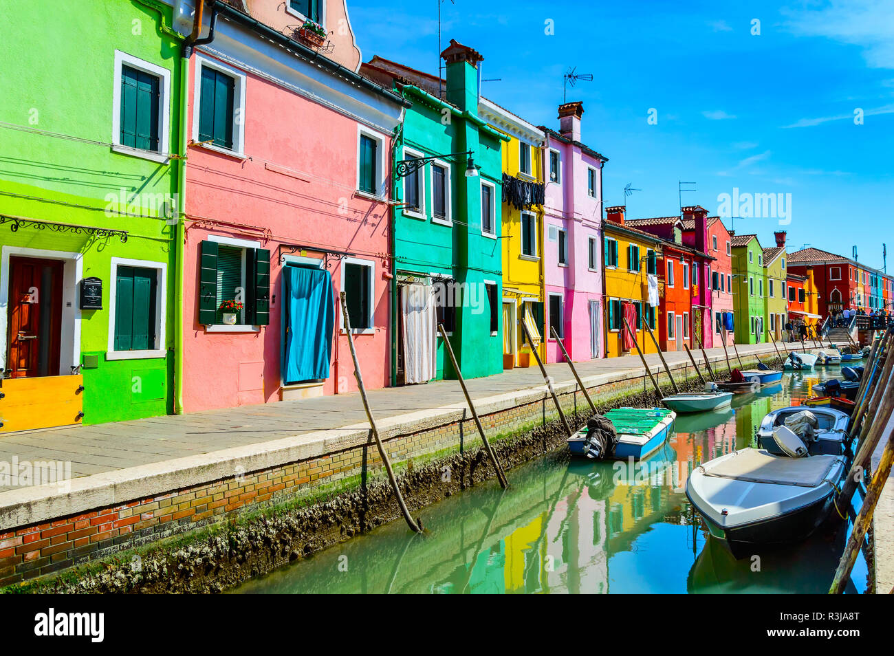 Colorful houses near canal on Burano island, Venice, Italy. Burano is a popular tourist attraction, famous for its lace work and brightly painted home Stock Photo