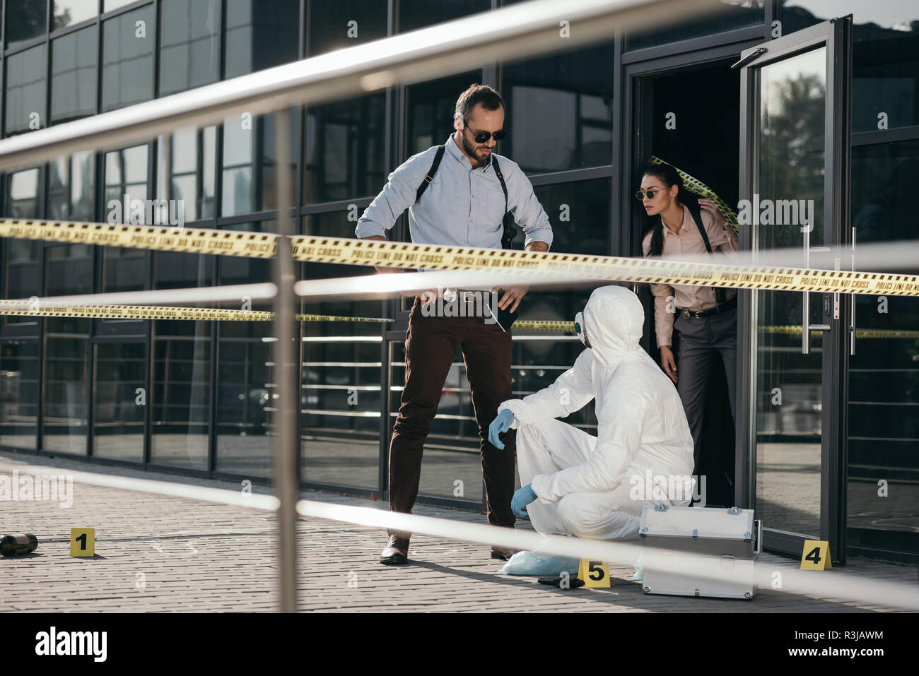 detectives and criminologist in protective suit and latex gloves