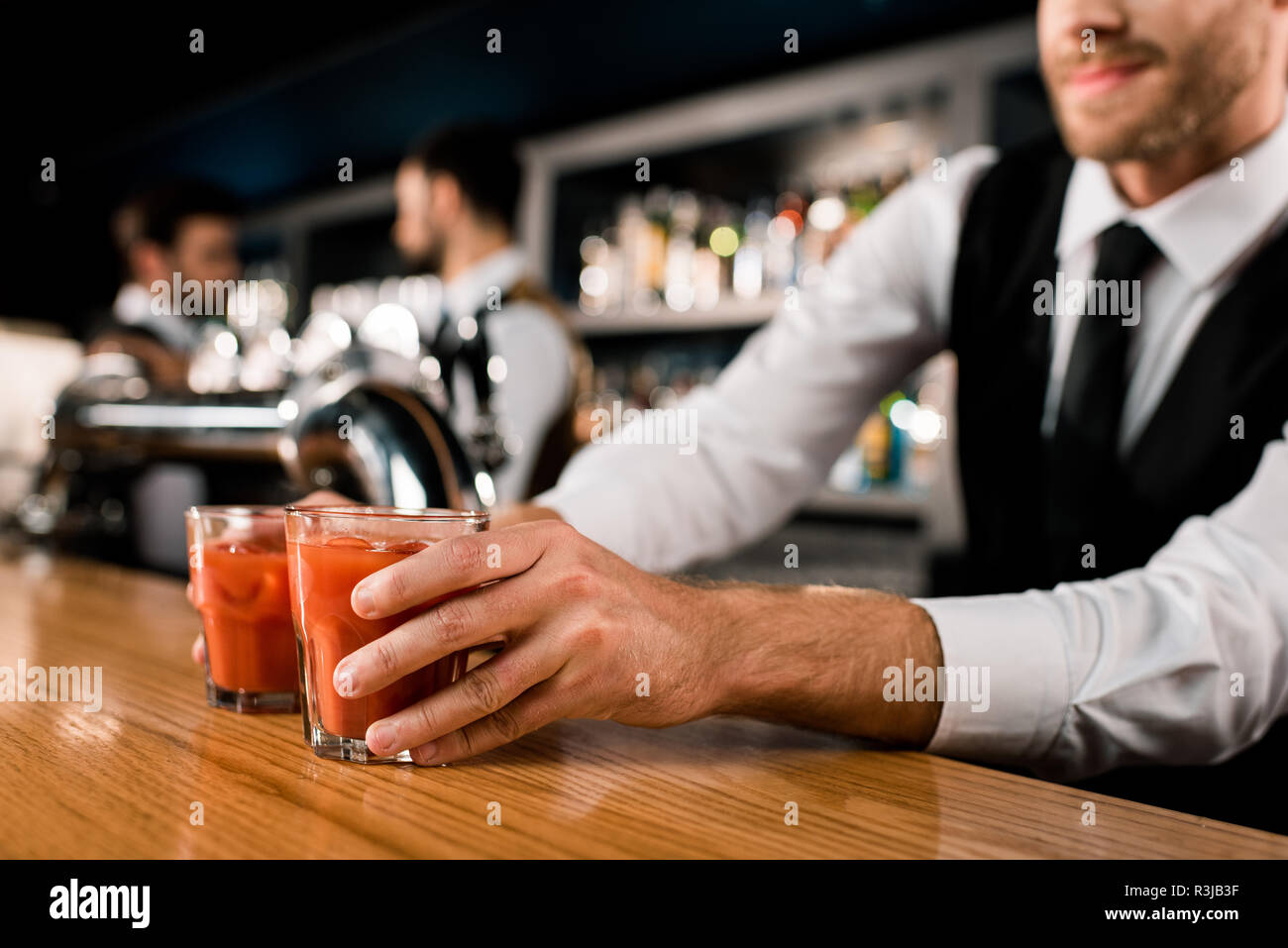 Bartender serving drinks in glasses on wooden counter Stock Photo Alamy