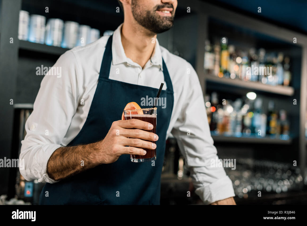 bearded barista in apron using shaker while working near coffee machine in  coffee shop Stock Photo by LightFieldStudios