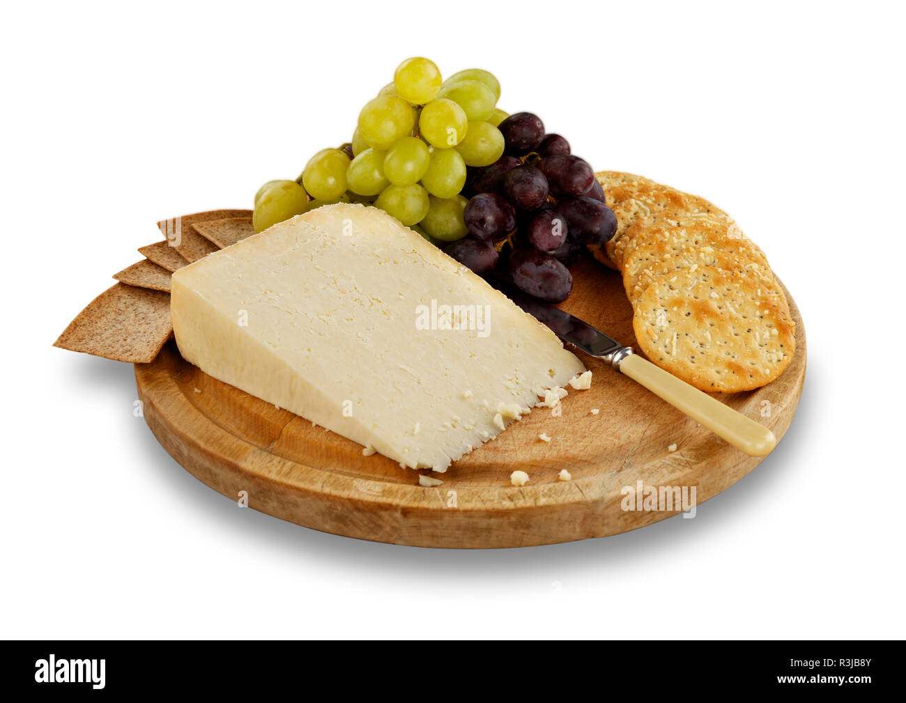 Isolated image of Cheese, crackers and grapes on wooden board. Stock Photo