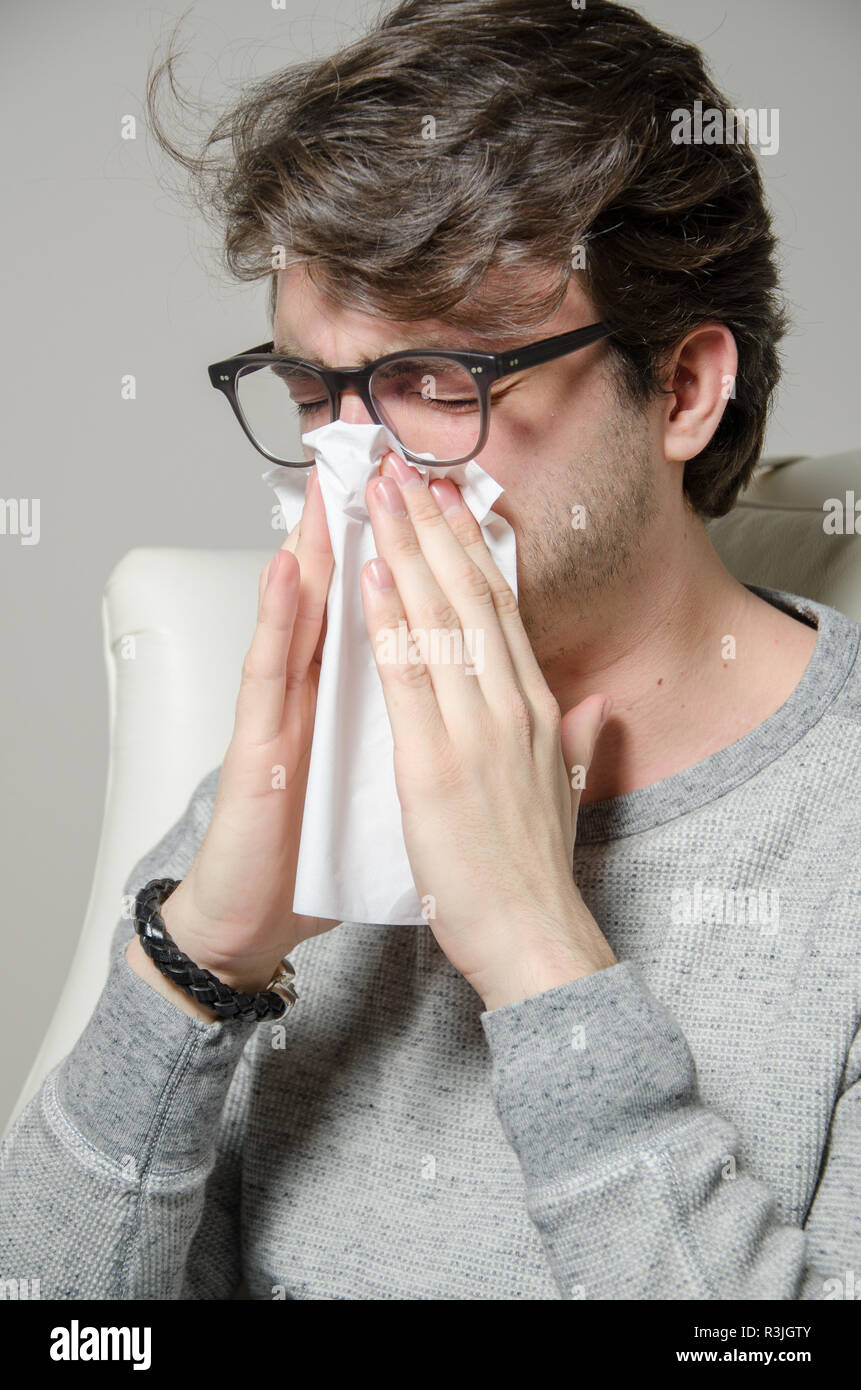 young man blows his nose nose Stock Photo Alamy