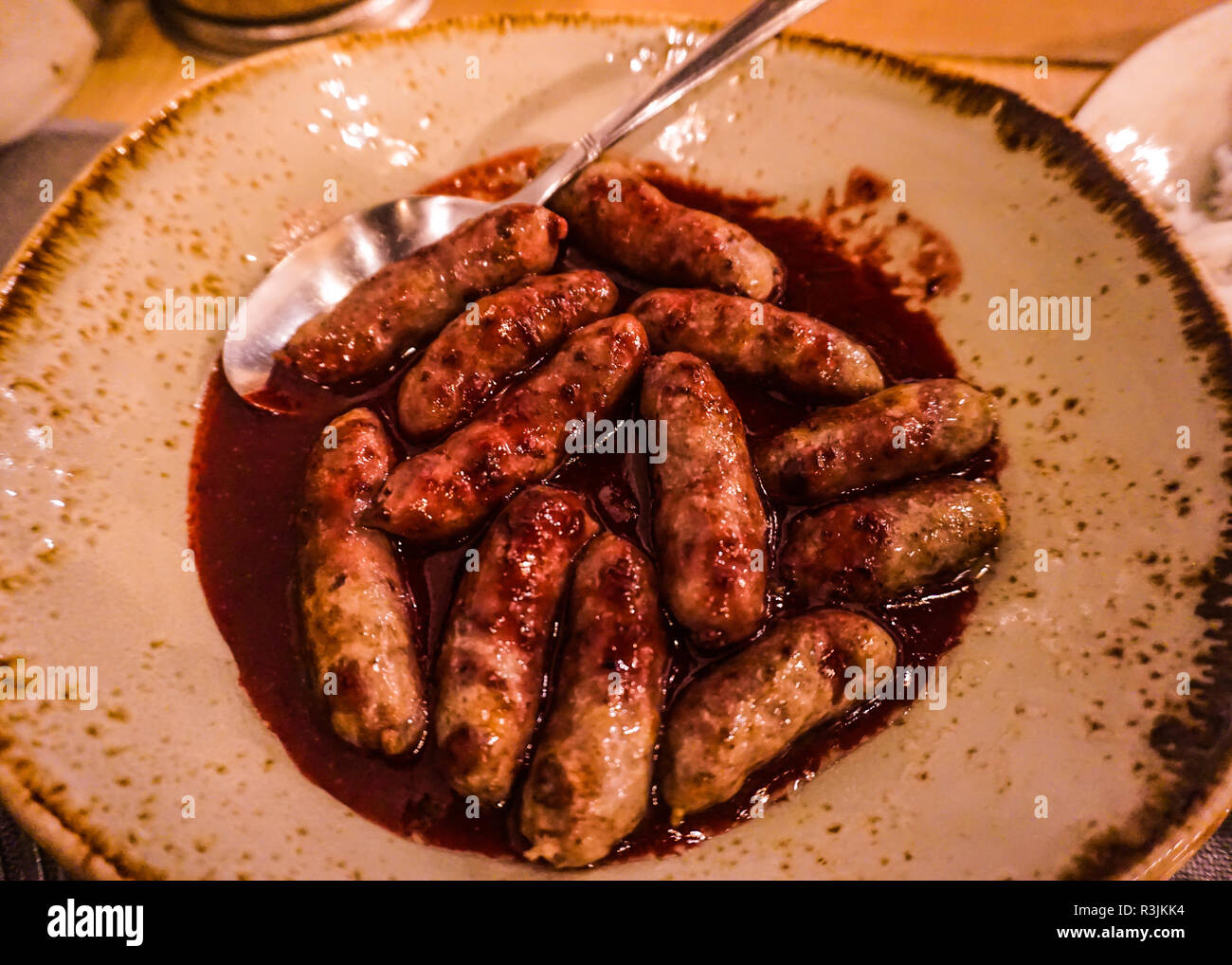 Traditional Armenian Cuisine Yershig with Dark Blackberry Sauce on a Plate Stock Photo