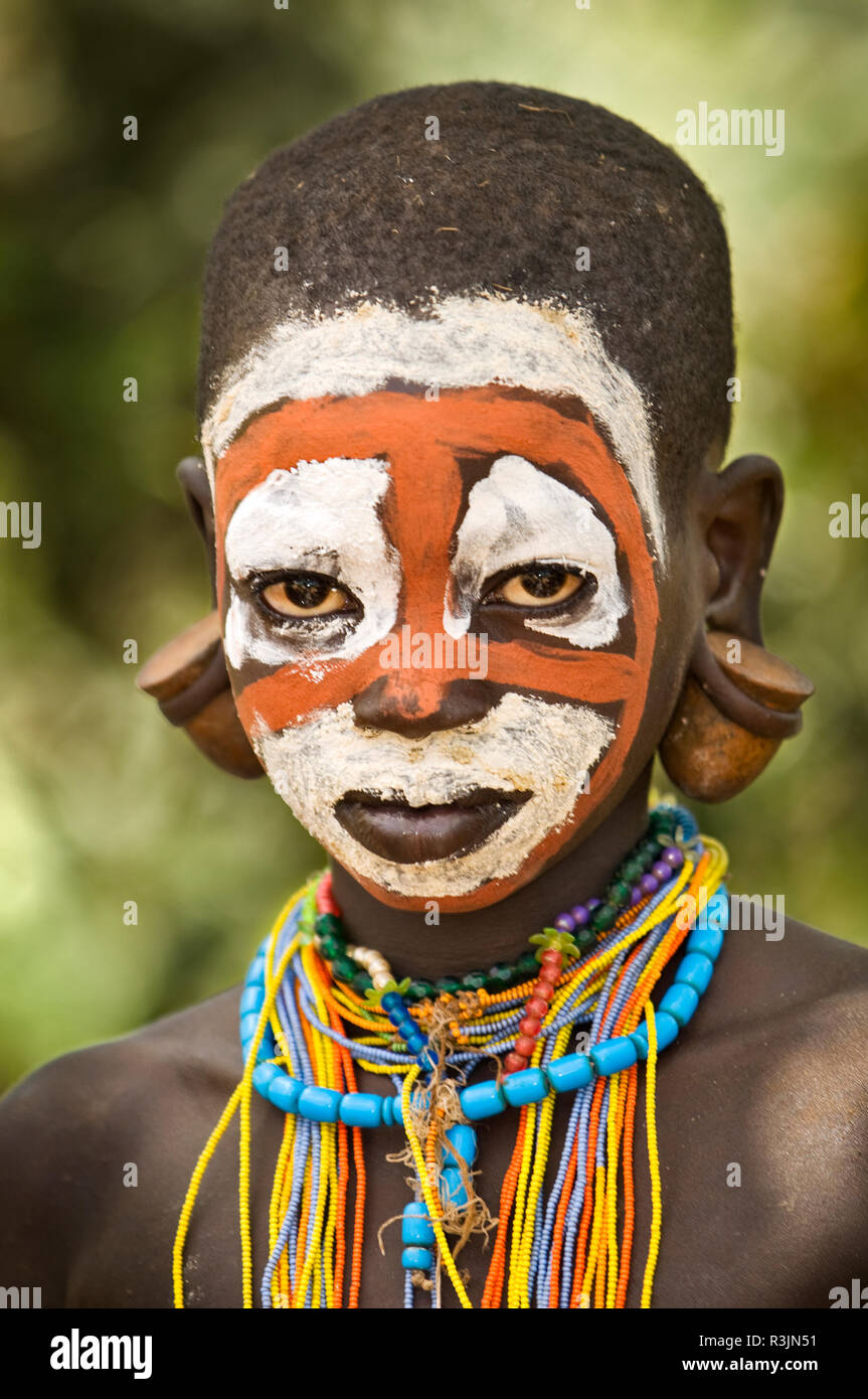 Africa, Ethiopia, Omo River Valley, Suri tribe. Grandson of chief Bologedung (Bulugedong) with painted face in chief's compound near Kibish village. Stock Photo
