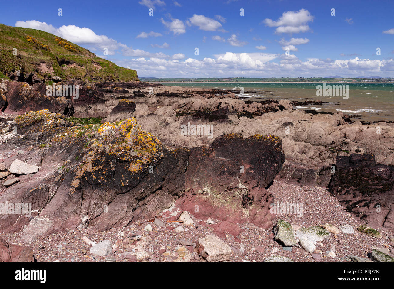 Red rocks on the shore at Youghal, County Cork, Ireland Stock Photo