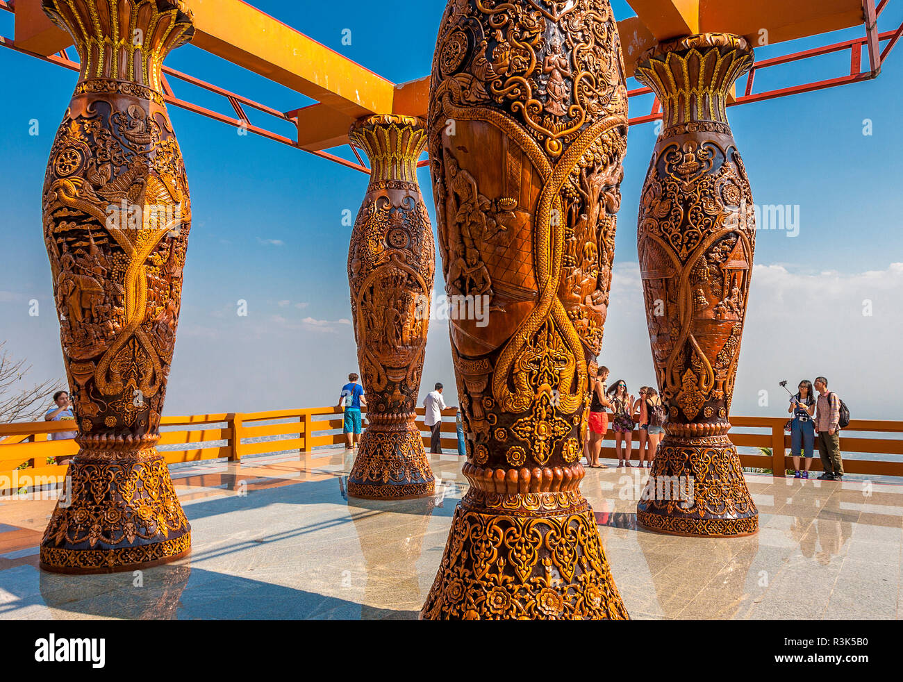 Large carved pillars and toursits on deck overlook of the city of Chiang Mai, Thailand Stock Photo