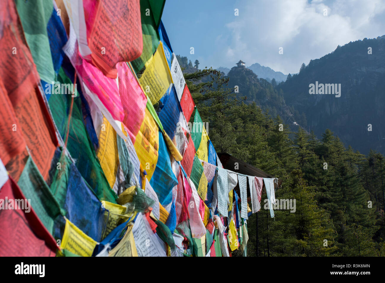 Bhutan, Paro. Colorful prayer flags in front of small outbuilding of the Tiger's Nest, sacred Himalayan Buddhist temple complex. Stock Photo