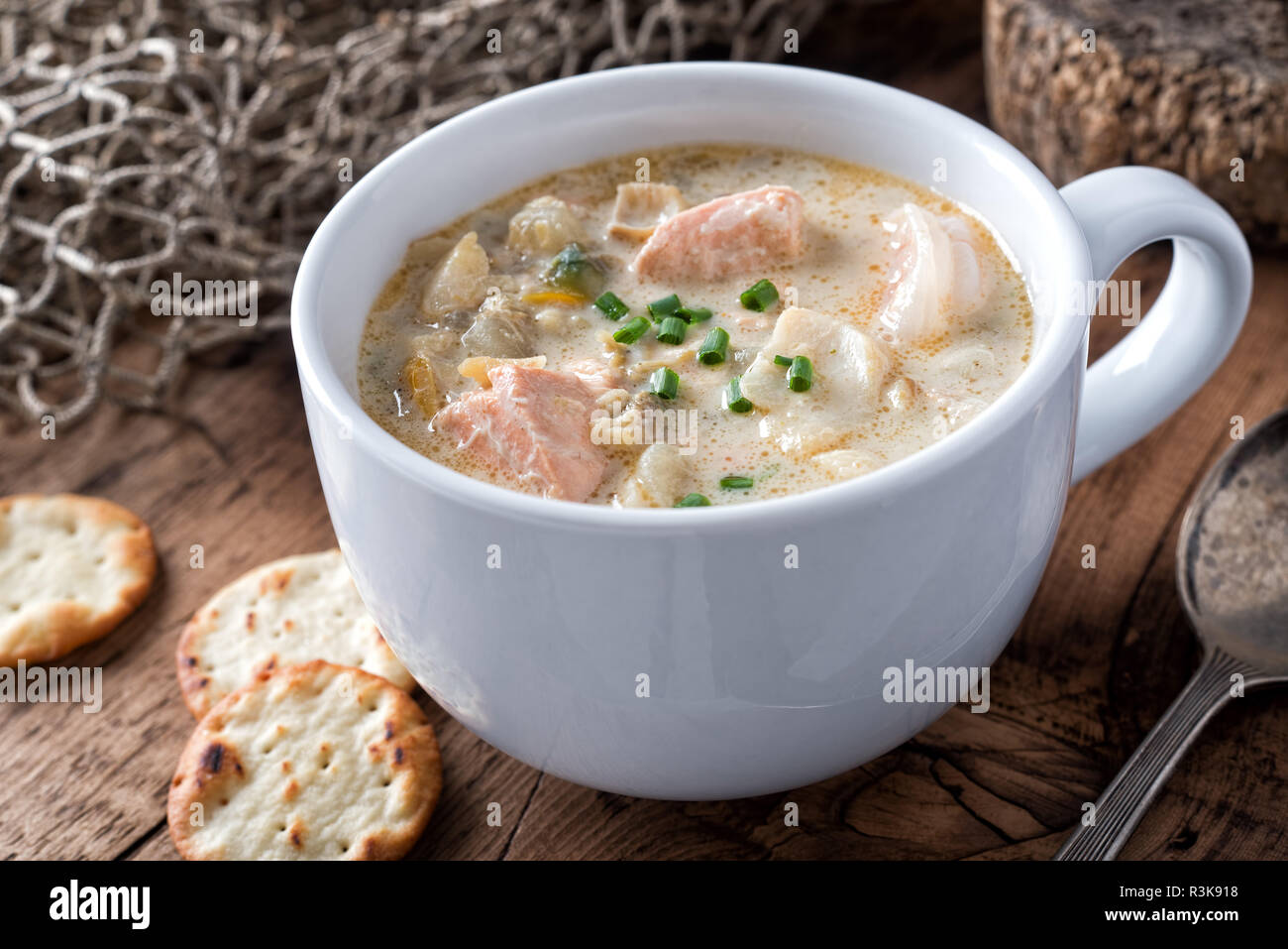 A cup of delicious homeade seafood chowder with salmon, haddock, scallops, clams and shrimp. Stock Photo