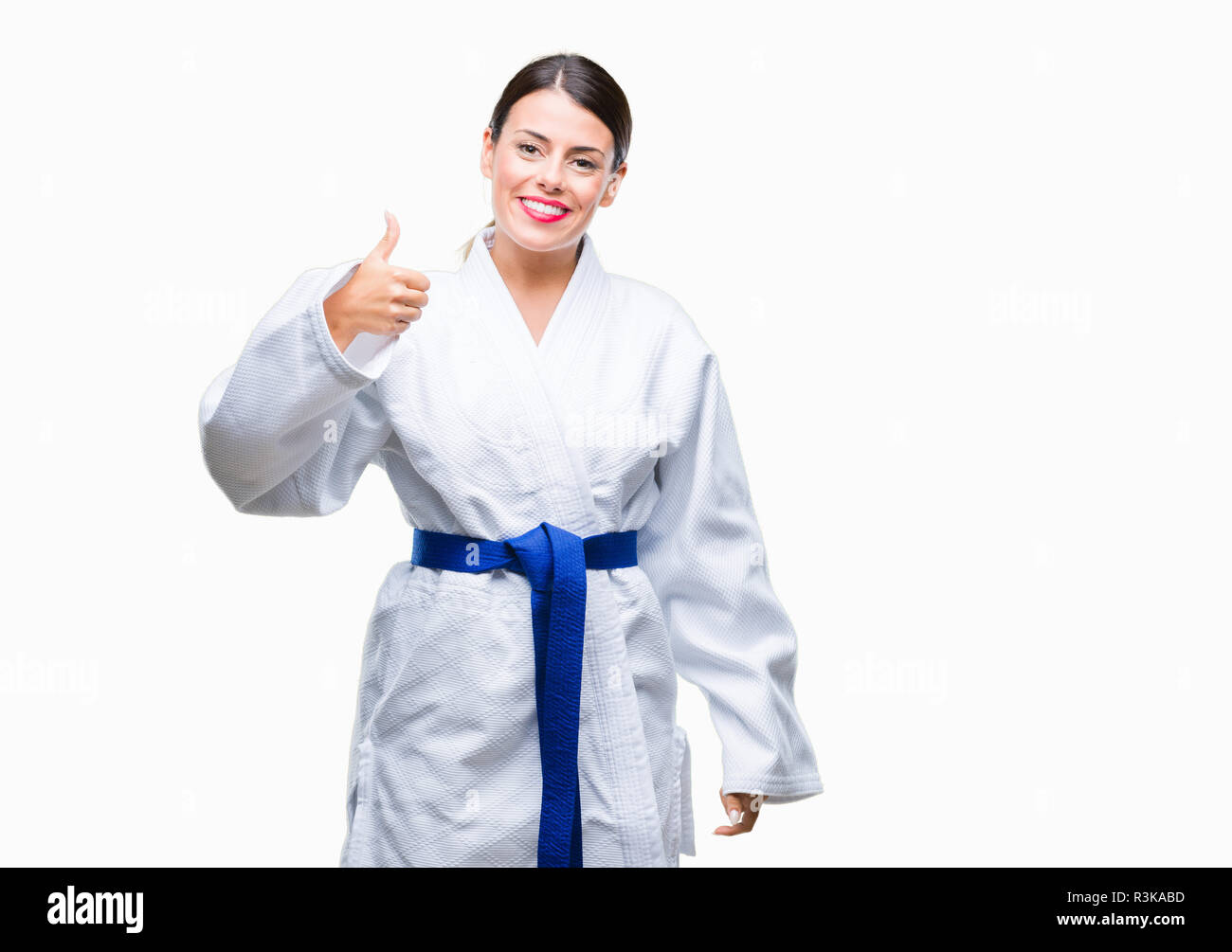 Young beautiful woman wearing karate kimono uniform over isolated background doing happy thumbs up gesture with hand. Approving expression looking at  Stock Photo